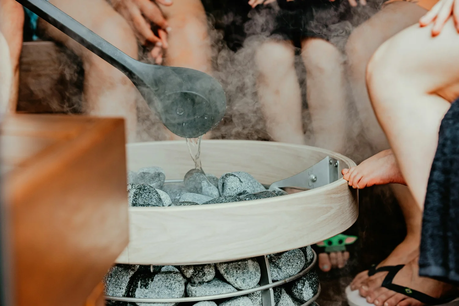 Water being poured over hot sauna stones inside Cedar Room